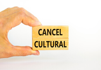 Cancel cultural symbol. Concept words Cancel cultural on wooden blocks on a beautiful white table white background. Businessman hand. Business and cancel cultural concept, copy space.