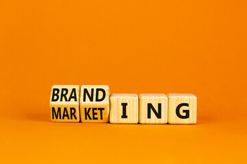 Branding and marketing symbol. Turned wooden cubes and changed the word Marketing to Branding. Beautiful orange table orange background, copy space. Business branding and marketing concept.