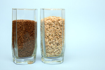 Glasses filled with flax seeds and oatmeal on a light background