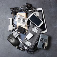 Old electronic devices on a dark background. The concept of recycling and disposal of electronic waste.