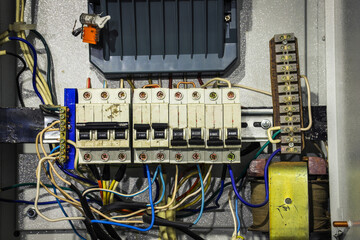 Cable chaos in electric control panel close-up. Tangled wires. Circuit breakers