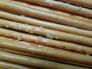 Crispy thin sticks (bread product) with coarse-grained salt.