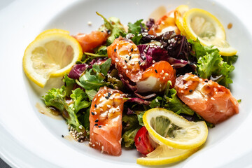 Salmon fish salad. Fresh vegetable lettuce and salmon fish fillet, healthy food, omega 3, keto diet, mediterranean cusine top view