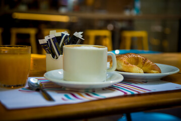 coffee with milk, orange juice and croissants