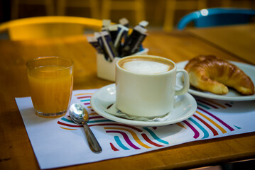 coffee with milk, orange juice and croissants