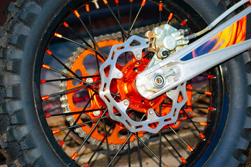 The disc brake of a cross-country motorcycle. Motorcycle brake system. Part of a motorcycle wheel. the rear wheel of the motorbike. Close-up.