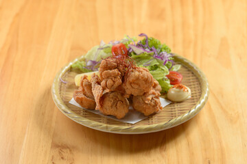 Japanese food deep fried chicken Tori Karaage in a wooden plate isolated on wooden background top view