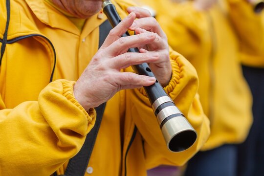Unrecognizable musician playing the Gralla (woodwind instrument) in the popular festivities of Barcelona (Spain), selective approach to the hand.