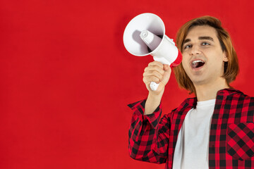Young man using an electric megaphone. Guy with speaking-trumpet, bullhorn, blowhorn, or...