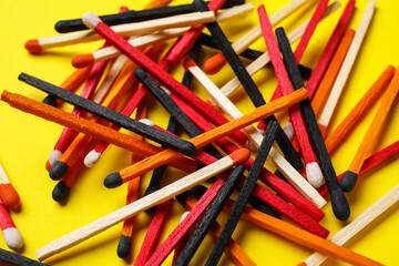 Fototapeta premium Heap of different new matchsticks on yellow background, closeup