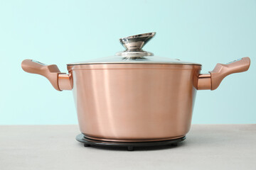 Shiny cooking pot on table against blue background