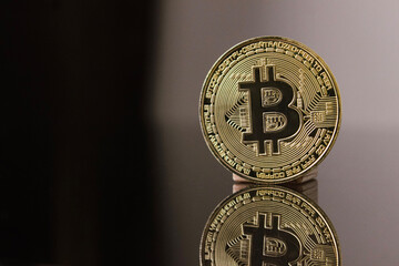 Bitcoin coin - golden Bitcoin coins on black mirror surface