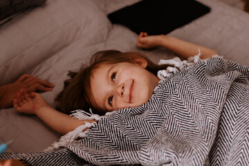 Cute toddler girl lying in bed, sleeping. Family life with daily routine.