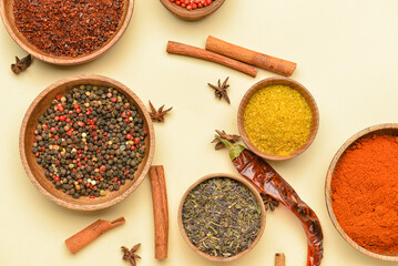 Bowls with aromatic spices on yellow background