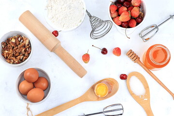 Kitchen background, cooking, Strawberry cherry pie recipe. Eggs, flour, sugar, strawberries and honey, top view, flat lay. Bakery background, modern bakery concept,