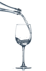 Pouring of clear water in glass isolated on white