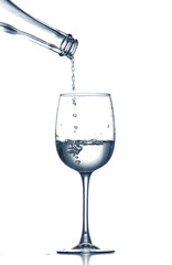 Pouring of clear water in glass isolated on white