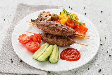 Plate of skewers with tasty lula kebab and vegetables on light background