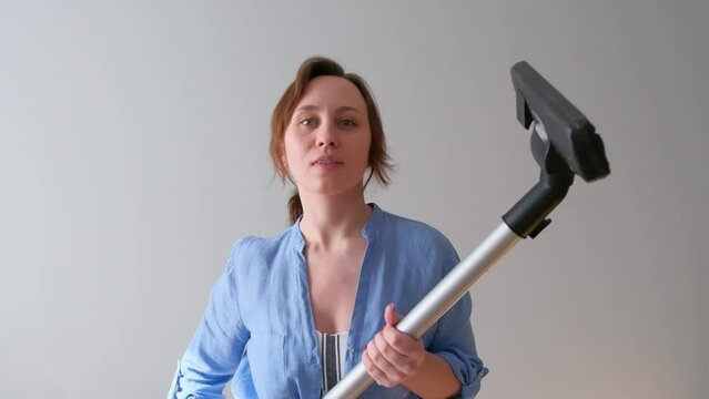 The girl lifts the vacuum cleaner