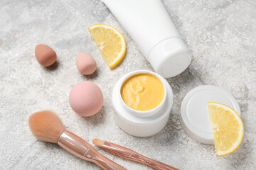 Composition with turmeric mask, makeup brushes, sponges and lemon on light background