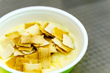 Cheese soup with fried croutons in a plastic plate