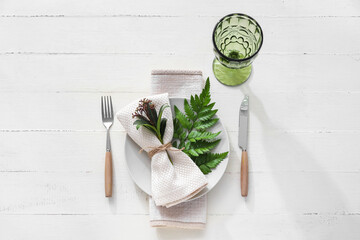 Stylish simple table setting on light wooden background