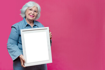 beautiful older woman showing a painting to the camera
