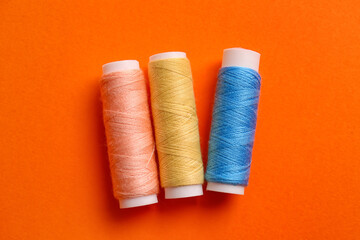 Thread spools on orange background