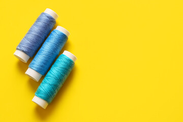 Thread spools on yellow background