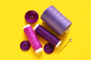 Thread spools with buttons on yellow background