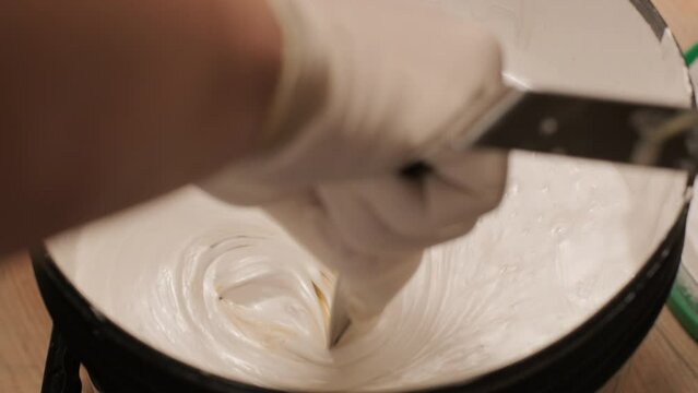 A worker kneads the paint for painting the walls
