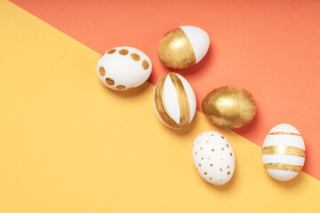 Hand-drawn easter eggs on yellow and orange pastel background. Many easter eggs flat lay background.