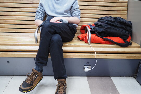 Railway station, a young man charges a mobile phone in the waiting room of the railway station. High quality photo