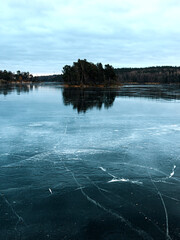 Cracks on the surface of the ice on lake Magelungen.  Frozen lake in wintery forest. Farsta, Sweden.