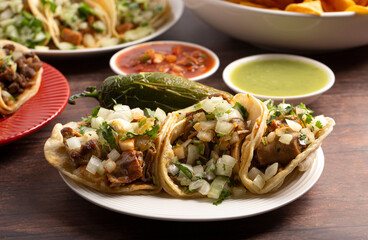 Three Delicious Buche Street Tacos in a Row on a Wooden Table
