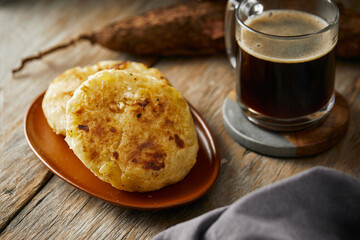 Tortilla de yuca a traditional Ecuadorian appetizer served with coffee. It’s on a wooden...