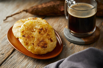 Tortilla de yuca a traditional Ecuadorian appetizer served with coffee. It’s on a wooden background.