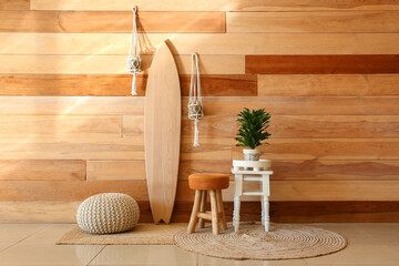 Interior of stylish room with wooden surfboard and houseplants