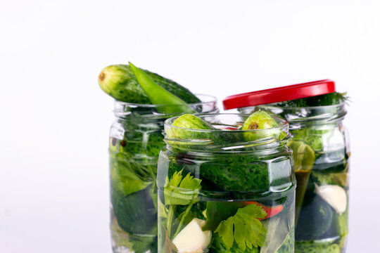 Pickled cucumbers in glass jar on white background. cloce up image.