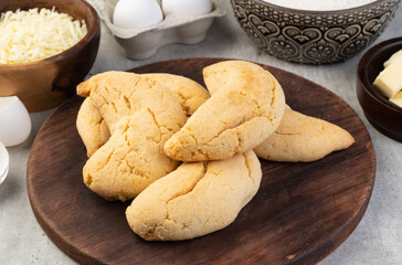 Chipas, typical south american cheese bun over wooden table with ingredients