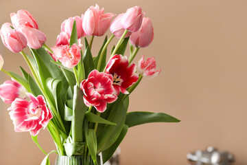 Beautiful bouquet of tulips on beige background, closeup