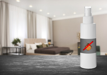 Anti bed bug spray on wooden table in bedroom. Space for text