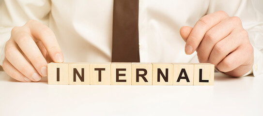 internal on wooden cubes, dice or blocks showing the words external and internal on blue background.Business concept.