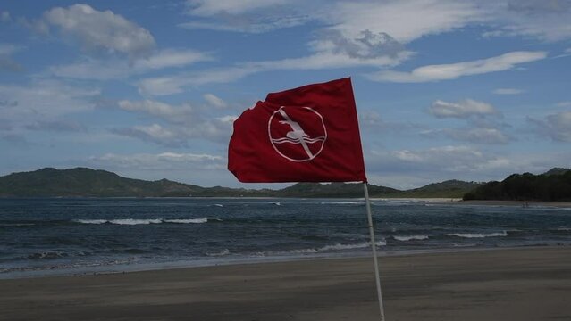 A danger flag o the beach blowing in slow motion.