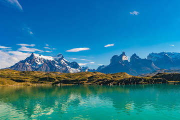 Peaks of Torres in the Torres del Paine National Park over Pehoe lagoon with turquoise in color...