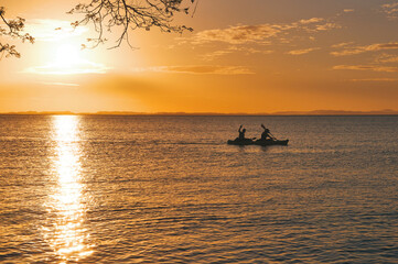 Silhouette of people kayaking at sunset on the lake at Ometepe island, Nicaragua