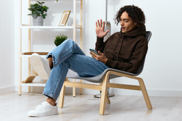 handsome guy sitting on a chair with a phone communication interior Lifestyle