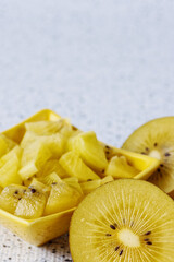 Golden kiwifruit chopped chunks in a bowl. Fresh kiwi fruit salad snack.