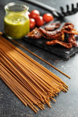 Uncooked whole grain spaghetti. Raw pasta on kitchen table.