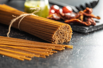 Uncooked whole grain spaghetti. Raw pasta on kitchen table.